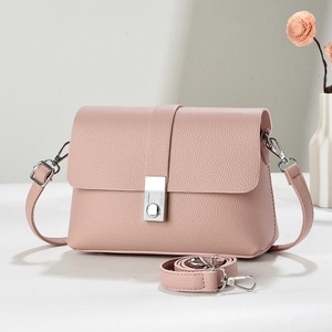 Close-up of pink litchi grain texture on crossbody bag with silver buckle detail
