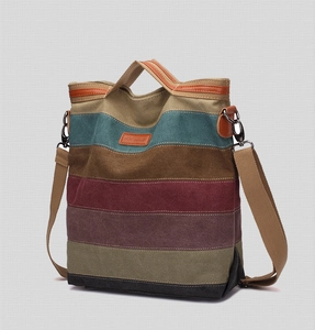 Detail of colorful striped canvas handbag with FANDARE leather logo and soft fabric texture