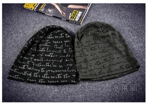 Close-up of two knit slouchy beanies with letter print in black and army green