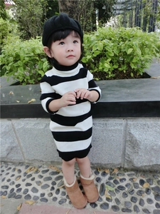 Detail shot of a black and white striped knit toddler dress with a high collar neck