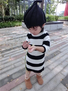 Detail of children's black and white striped knit dress with long sleeves and boots
