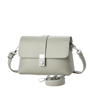 Light gray pebbled leather crossbody bag with silver clasp lock on white background