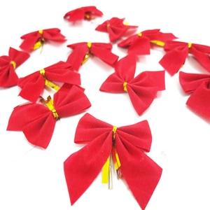 Close-up of red flocked Christmas bows with gold ties for tree DIY decoration