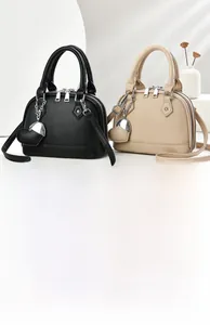 Detail of lychee textured leather mini dome bags with heart charms and metal zippers
