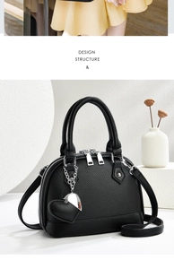 Detail of black shell tote bag with lychee grain leather and heart-shaped charm accessory