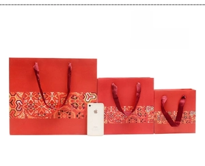 Three sizes of red Chinese style gift bags with silk handles and gold pattern details