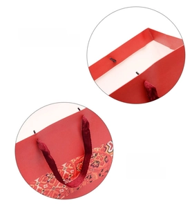 Close-up of red ethnic gift bag showing 250g white cardstock and silk rope handle