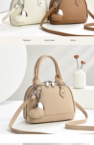 Detailed view of lychee pattern shell tote bags with heart pendants in neutral tones
