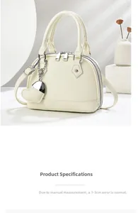 Detail of lychee pattern leather tote bag with heart charm and secure dual metal zippers