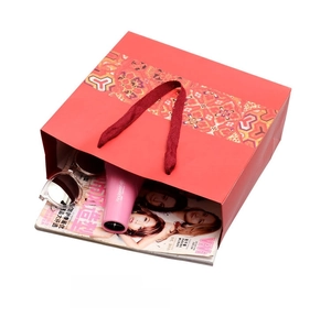 Red Chinese ethnic style paper gift bag showing interior capacity with fashion items