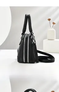 Detail of black lychee grain leather tote bag with dual zippers and silver metal buckles