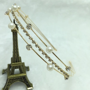 Detail shot of a golden headband featuring elegant white pearls and sparkling rhinestones