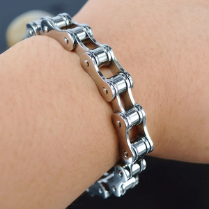 Close-up of a silver stainless steel bicycle chain bracelet on a male wrist