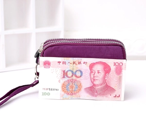 Detail of a purple washed denim wristlet with three zipper layers for organization