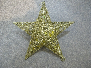 Macro view of gold hollow star ornament with glittering sequins for Christmas decor