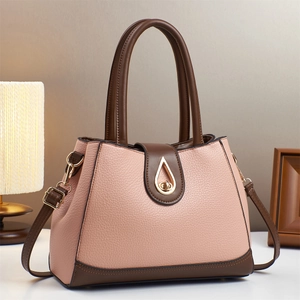 Sac à main en cuir rose avec poignées marron et fermoir doré dans un décor de style de vie