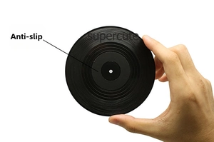 Close-up of a hand holding a black non-slip vinyl record coaster with realistic textures