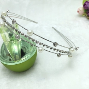 Detail view of double-layered silver headband with white pearls and sparkling rhinestones