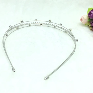 Detail of silver headband with elegant white pearls and sparkling rhinestones on white base