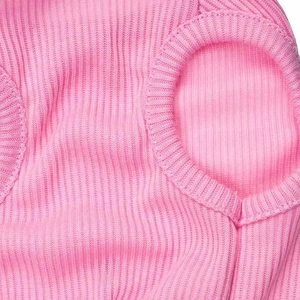 Close-up of pink ribbed knit fabric texture and sleeve detail on a pet vest