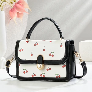 Elegant white crossbody bag with red cherry prints and black leather trim for women