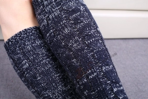 Detail of navy blue chunky knit pattern featuring cable twists and openwork mesh texture
