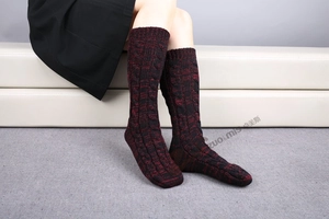 Detail of cable knit pattern on thick black and red mélange wool socks for winter