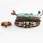 Detail of multi-layer leather bracelets and skull ring with ethnic braided rope elements