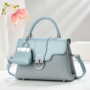 Light blue patchwork handbag with metal ring clasp and stylish woven texture detail