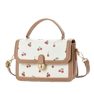 Elegant cream square crossbody bag with red cherry print and brown leather handles