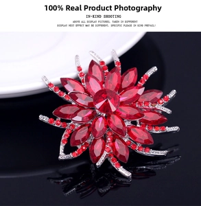 Macro view of crystal flower brooch featuring radiant red rhinestones and silver alloy base
