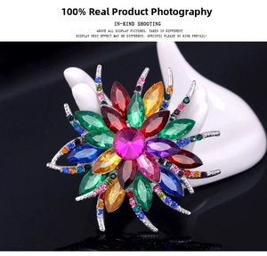 Macro shot of a colorful flower crystal brooch with vibrant rhinestones on a display hand