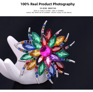 Macro detail of colorful crystal floral brooch with silver alloy base on black background