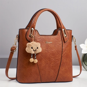Brown faux leather tote bag with top handle, shoulder strap and plush cloud charm