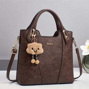 Classic vintage brown faux leather handbag with gold hardware and plush charm decoration
