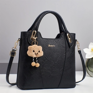 Elegant black faux leather tote bag with gold hardware and a cute cloud charm pendant