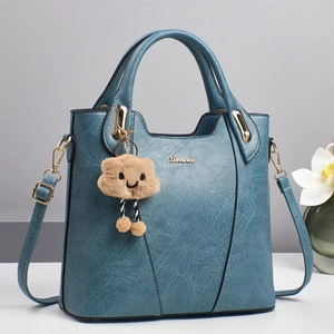 Blue crocodile textured bucket bag with gold logo and cute plush cloud charm