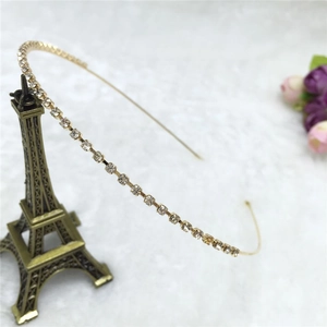 Detail of slim gold metal headband featuring a single row of sparkling rhinestones
