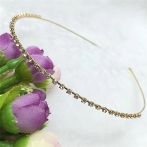 Close-up of elegant gold metal headband with sparkling rhinestones on plush background