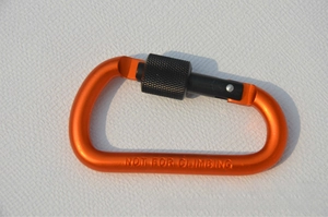 Detail of orange D-ring carabiner with black screw lock and Not For Climbing engraving