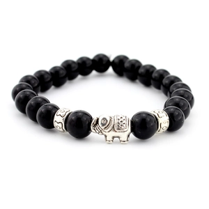 Macro detail of black agate beads and vintage silver elephant charm on a beaded bracelet