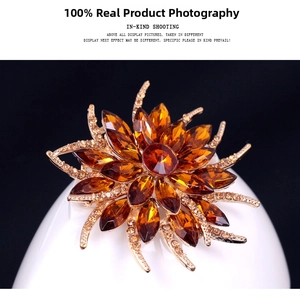 Detailed close-up of amber crystal flower brooch with gold plating and rhinestones