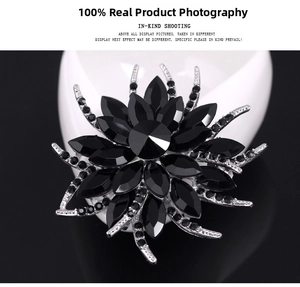 Detail of floral crystal brooch with black faceted rhinestones and silver alloy base