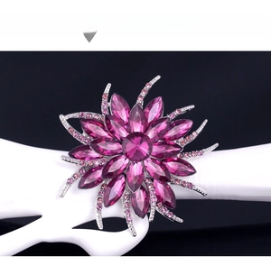 Detail view of purple floral crystal brooch with marquise-cut stones on a hand display