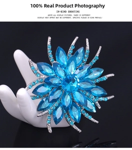 Macro view of blue crystal flower brooch pinned on a white ceramic hand model