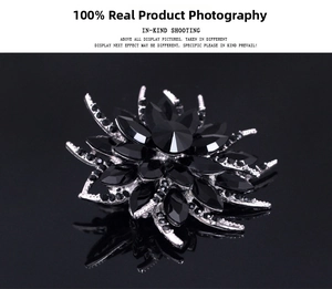 Detailed view of a vintage floral crystal brooch with black marquise stones on black reflection