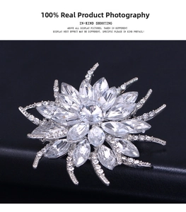 Close-up of snowflake crystal brooch with silver base on black leather texture background