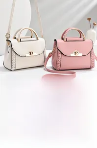 Dettaglio di piccole borse a tracolla beige e rosa con chiusura a rotazione in metallo