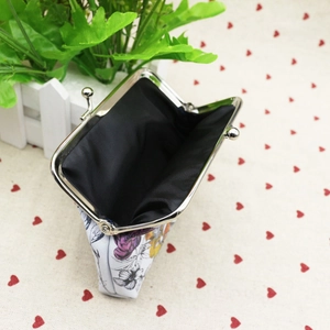 Detail view of floral PU leather coin purse with silver metal clasp and black lining