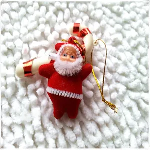 Detail of Santa Claus and candy cane hanging ornaments with gold string on plush surface